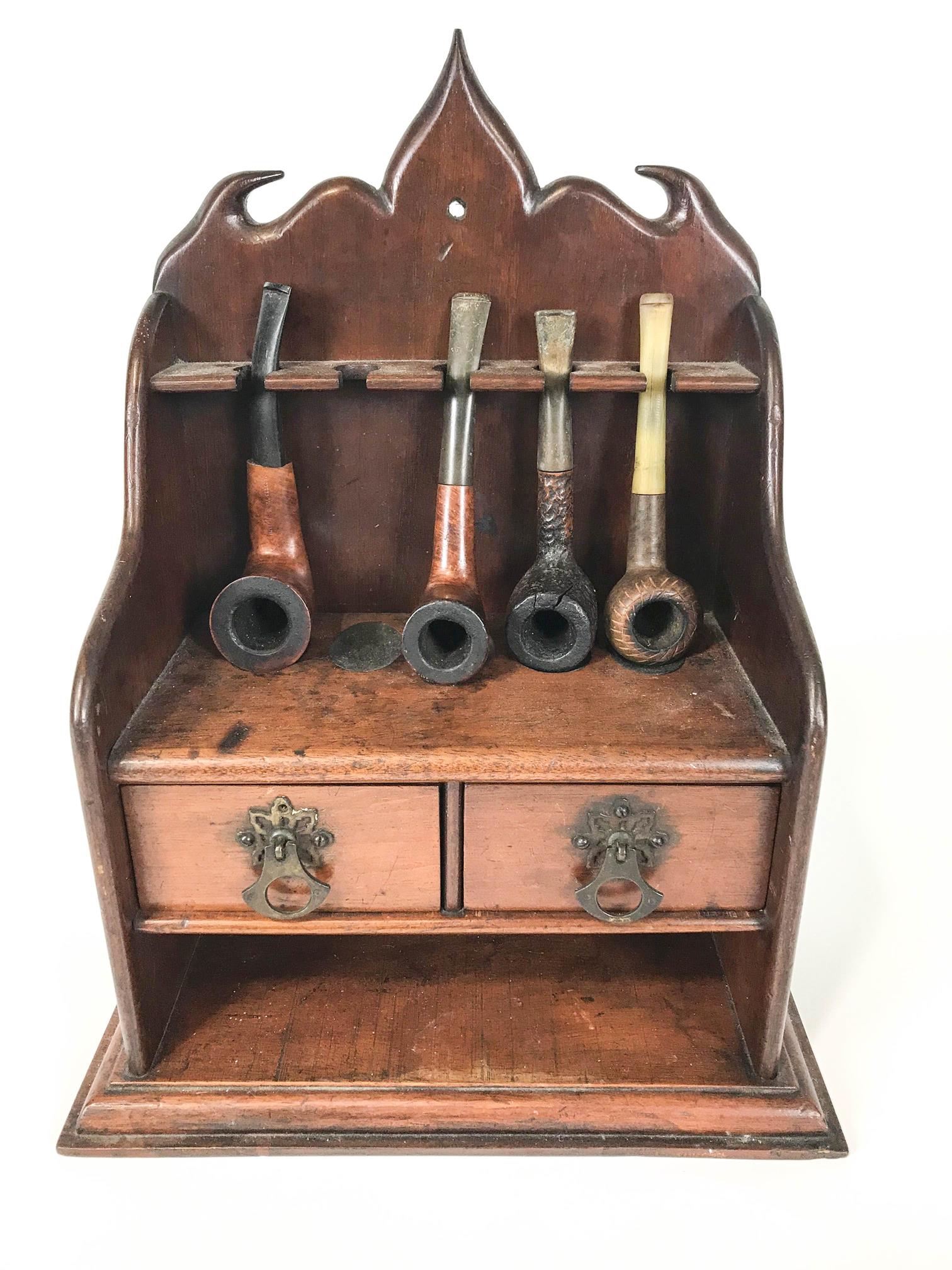 A 19th century mahogany pipe stand and four pipes,