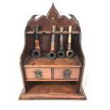 A 19th century mahogany pipe stand and four pipes,