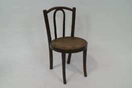 A bentwood child's chair with solid seat and flared legs,