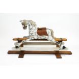 A 20th century rocking horse, with leather saddle, dappled in black and white and brindle,
