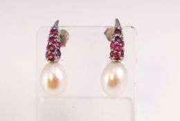 A white metal pair of drop earrings.