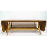 An Ercol light elm drop-leaf low coffee table, of rectangular form, with lower tier on splayed legs,