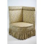 An upholstered corner chair, with padded back and seat ,