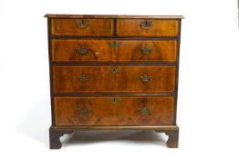 A Georgian veneered walnut chest of drawers with satinwood stringing,