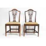 A pair of George III mahogany chairs, each with pierced splats and arched top rail,