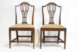 A pair of George III mahogany chairs, each with pierced splats and arched top rail,