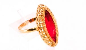 A yellow metal dress ring set with a marquise cut synthetic ruby.
