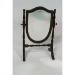 A 19th century mahogany shield shaped swing mirror, inlaid with stringing,