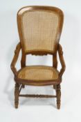 A Victorian cane armchair, stamped T H to reverse,