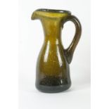 A 19th century glass jug with applied scroll handle, the concave underside with pontil mark,