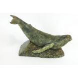 A Studio pottery simulated bronze model of a whale a crest waves,