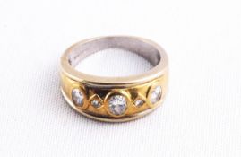 A yellow metal ring set with three oval faceted cut diamonds
