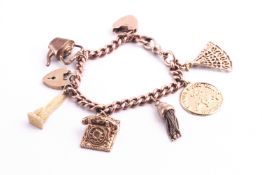 A rose gold curb link charm bracelet with padlock and safety chain having six assorted charms