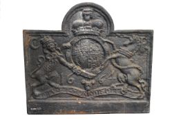 A cast iron fire back, cast with the Crowned Royal Arms, of arched rectangular form,