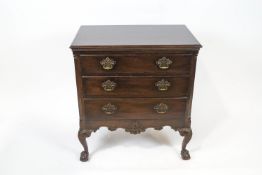 A mahogany chest of three drawers with fluted canted corners on carved cabriole legs