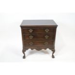 A mahogany chest of three drawers with fluted canted corners on carved cabriole legs