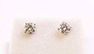 A white metal pair of single stone stud earrings.