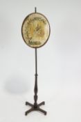 A mahogany pole screen, 19th century, the oval screen with silk embroidery of flowers,