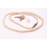 A tie pin set with an 8mm white cultured pearl together with a single strand of simulated pearls