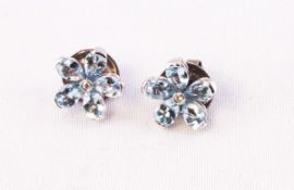 A white metal pair of floral stud earrings each set with five pear cut aquamarines