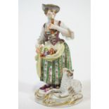A porcelain Meissen style figure of a shepherdess playing a pipe, in polychrome clothing,