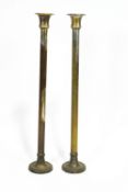 A pair of silvered brass ecclesiastical floor candlesticks, or plain columnar form,
