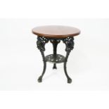 An oak topped pub table, on black painted cast iron base, moulded with classical masks,