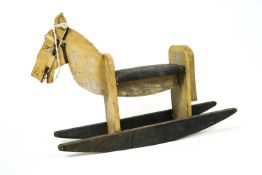 A vintage painted wood rocking horse of simple plank construction,