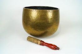 A brass singing bowl and striker, 32cm high,