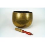 A brass singing bowl and striker, 32cm high,