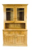 A pine dresser, with two panelled glazed doors enclosing two shelves,