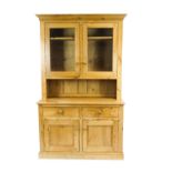A pine dresser, with two panelled glazed doors enclosing two shelves,