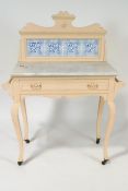 An Edwardian painted washstand with raised tiled back above a marble top, with frieze drawer,