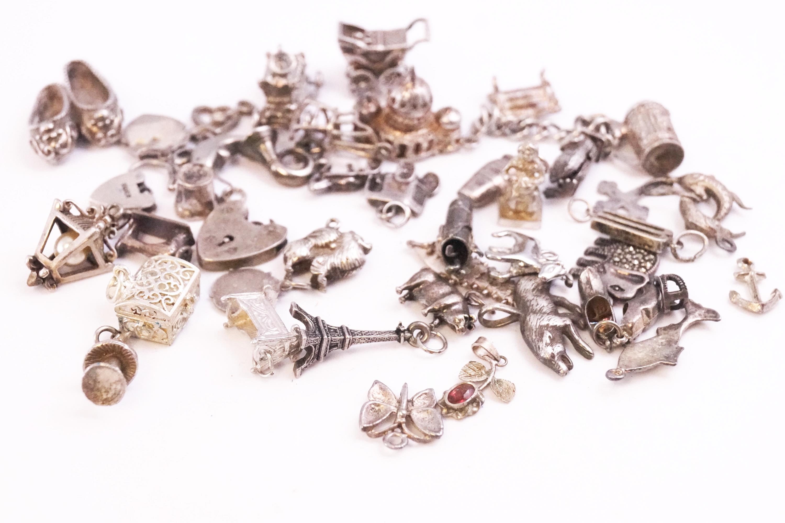 A collection of forty silver charms of variable designs. Most are marked 925 for sterling.