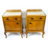 A pair of 1920's Warring and Gillows satinwood bedside cupboards with a pierced frieze