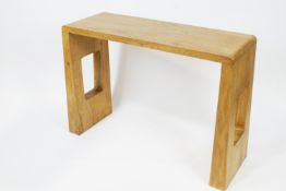 A 21st century elm console table, the flared end supports with pierced rectangles,