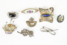 A collection of eight brooches of variable designs.