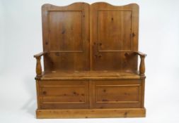 A pine box settle, of traditional form, with turned arms and panelled back,
