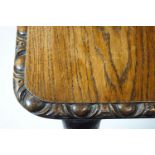 An oak rectangular extending dining table, carved with egg and dart edge,