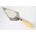 A silver and ivory presentation trowel, of usual form, the blade decorated with scroll work,