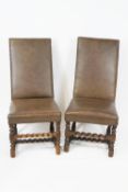 A pair of chairs with leatherette studded backs and seats on barley twist legs