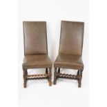 A pair of chairs with leatherette studded backs and seats on barley twist legs