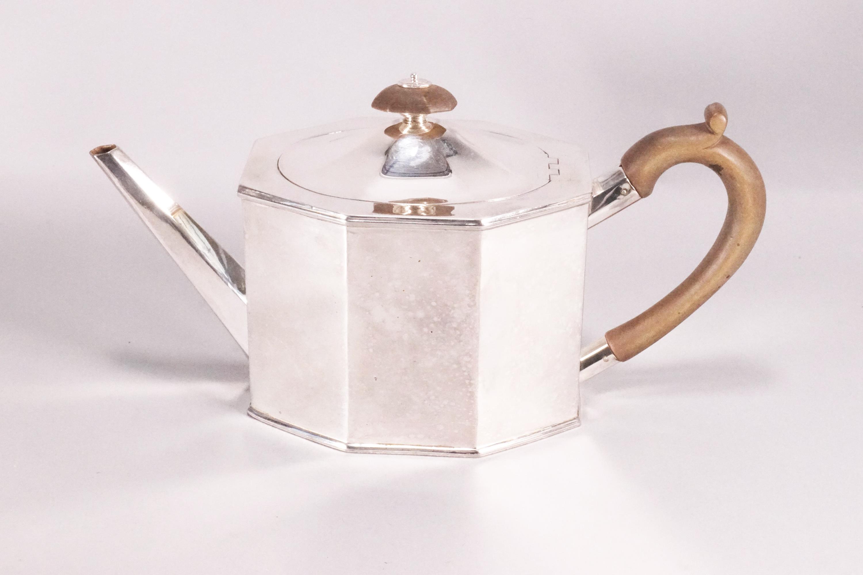 A silver teapot of flat panel octagonal form and domed cover,