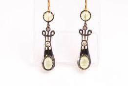 A yellow and white metal pair of drop earrings each set with cabochon cut peridot