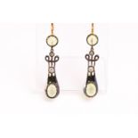 A yellow and white metal pair of drop earrings each set with cabochon cut peridot