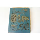 A late 19th century cloth bound card album with Art Nouveau gilt decoration to the cover