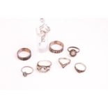 A collection of eight silver dress rings of variable designs.