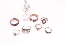 A collection of eight silver dress rings of variable designs.