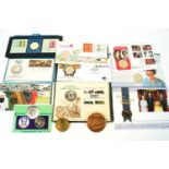 A collection of commemorative coins, medals and stamps,