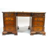 A mahogany partner's desk, the shaped top set a green leather skiver, over three drawers,